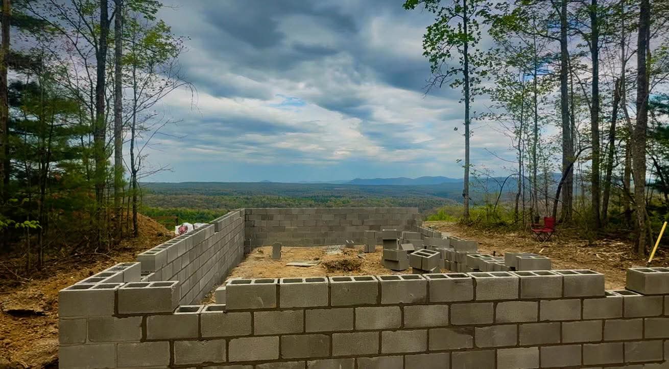 Foundation walls taking shape with mountain vista beyond