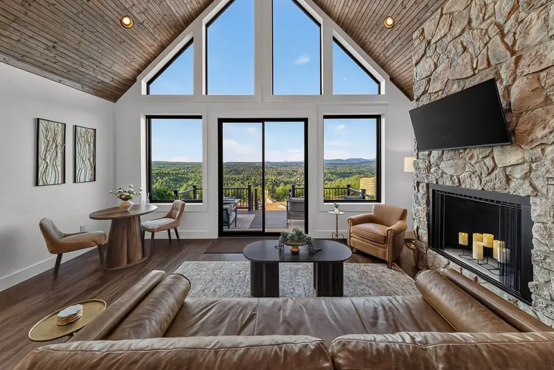 The fireside lounge with leather sofa, stone fireplace and mountain views