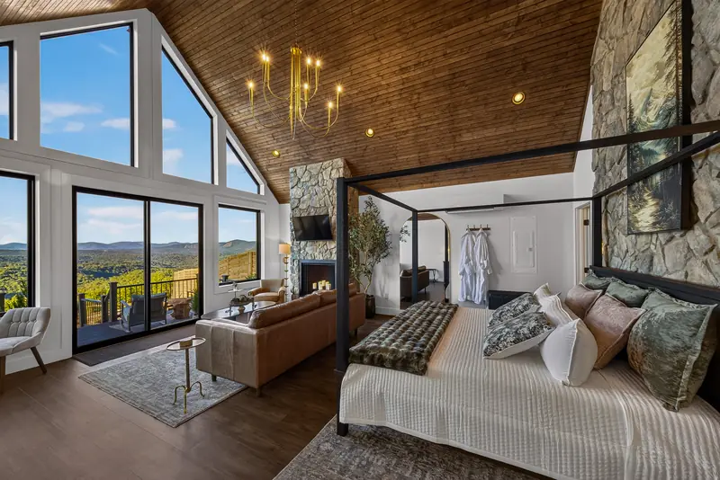 The four-poster canopy bed in white linens beneath the A-frame windows